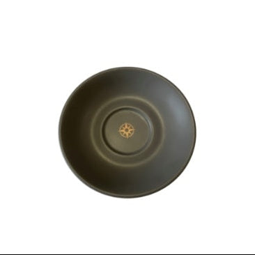 A black ceramic saucer with a floral pattern at the bottom