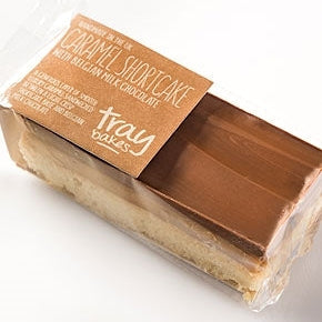 Packaged caramel shortcake with milk chocolate layered in between, wrapped in a clear plastic tray with a brown paper label that reads 'Caramel Shortcake' and the brand 'Traybakes'.