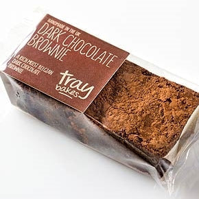 Packaged dark chocolate brownie from Traybakes with visible chocolate chunks on the top layer.