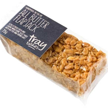 Packaged all butter flapjack from Traybakes Books, featuring a stack of oatmeal and butter flakes with a label on top.