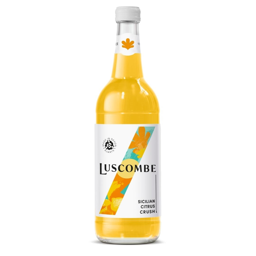 A bottle of Luscombe Sicilian Citrus Crush non-alcoholic syrup, filled with bright yellow-orange liquid, featuring a white label with a colorful diagonal stripe design.