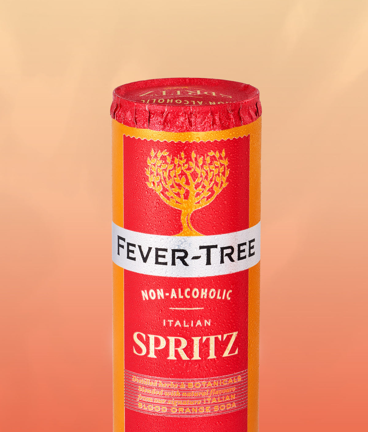 A cylindrical canister of Fever-Tree Non-Alcoholic Italian Spritz non-alcoholic beverage, featuring a red and orange label with a gold tree logo and a white band with black text, set against a warm peach gradient background.