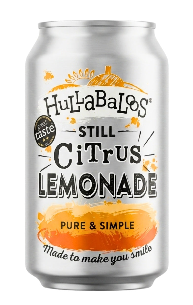 A silver aluminum can of Hullabalos Still Citrus Lemonade on a plain white background. The label features black text and orange watercolor-style graphics depicting citrus slices and a lemon.