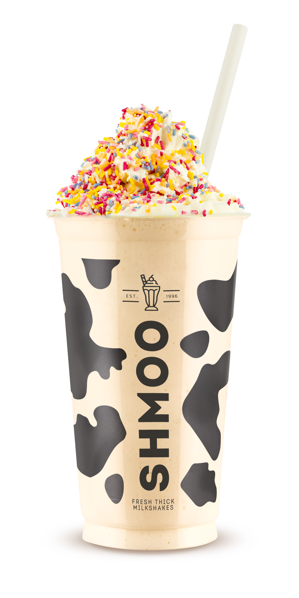 A large cup of milk with a cow print pattern, covered in multicolored sprinkles, and a straw is visible on the side.