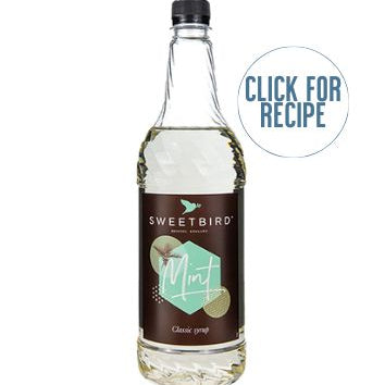 A bottle of SWEETBIRD mint syrup with a label that includes the brand name and the words 'click for recipe'. The bottle cap is black, and the syrup appears to be a clear liquid.