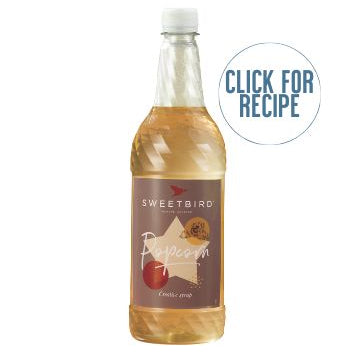 A bottle of Sweetbird popcorn syrup with a label that includes an illustration of a popcorn and text that says 'CLICK FOR RECIPE'.