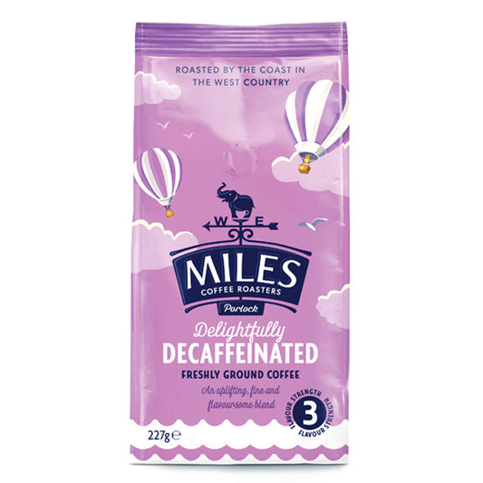 Packaging of MILES Delightfully Decaffeinated freshly ground coffee. The bag is purple with hot air balloon graphics and product information.