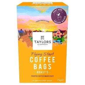 A box of Taylors Flying Start Coffee Bags, featuring a colorful packaging with an image of a coffee plantation and a sunset.