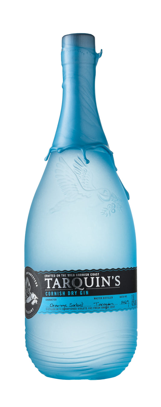 A bottle of TARQUINS MAGNUM CORNISH DRY GIN with a clear blue label, standing upright against a white background.