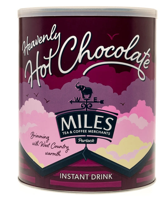 A tub of MILES brand Heavenly Hot Chocolate, instant drink, with a purple and pink color scheme and a graphic of a smiling face.