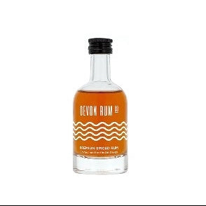 A small bottle of Devon Rum Premium Spiced with a visible label and orange liquid inside.