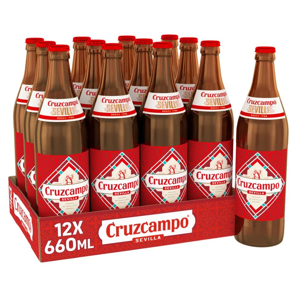 A 12-pack of Cruzcampo Sevilla 660ml beer bottles in a red cardboard carrier, with one bottle standing beside the tray on a white background.