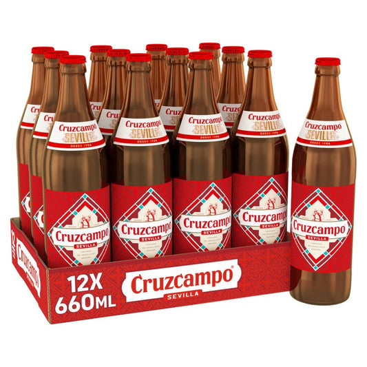 A 12-pack of Cruzcampo Sevilla 660ml beer bottles in a red cardboard carrier, with one bottle standing beside the tray on a white background.