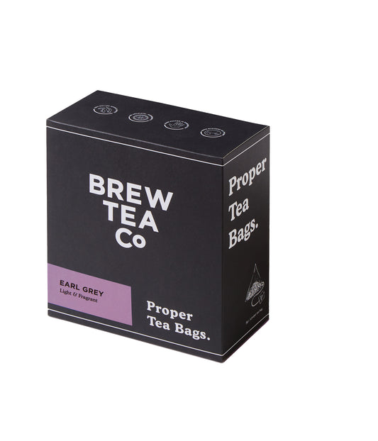 A box of BREW TEA CO. proper tea bags, Earl Grey Tea Bags to be specific, with a dark background and purple accents on the packaging.