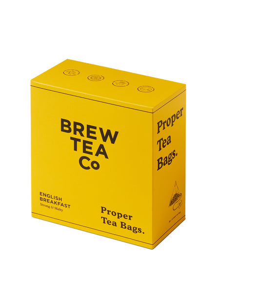 A yellow box of BREW TEA CO. proper tea bags with English Breakfast tea tagged on it.