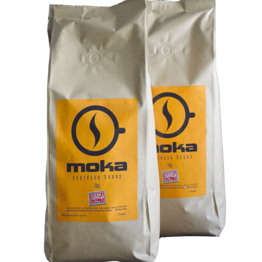 Two bags of MOKA café beans, with a prominent orange and black brand logo on the front.