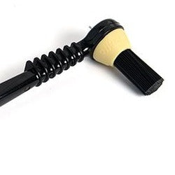 A coffee machine brush with a black handle and beige bristles.