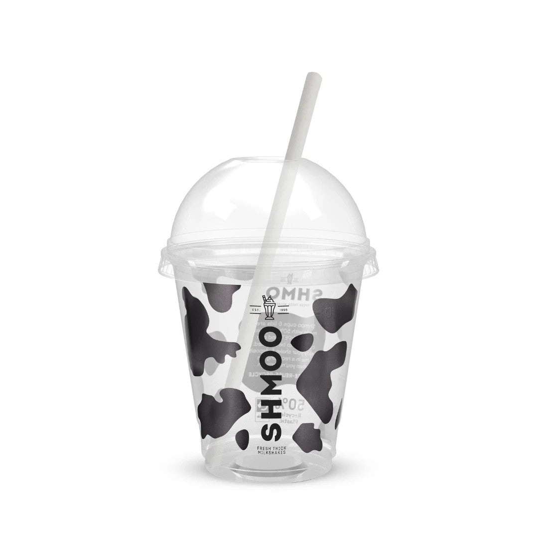 A clear plastic cup with a black and white cow print pattern, a clear dome lid, and a white straw. The cup features the vertical brand name 'SHMOO' in black.