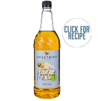 A bottle of SWEETBIRD SUGAR FREE HAZELNUT SYRUP LTR with a label showing the brand name and a hazelnut graphic, accompanied by a 'Click for Recipe' text.