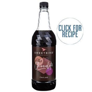 A bottle of Sweetbird chocolate syrup with a label that includes the brand name and the words 'click for recipe'. The bottle cap is on top of the syrup and there is a 'registered with The Vegan Society' textual hint.