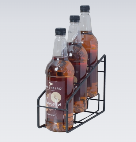 Three bottles of Sweetbird brand syrup in a metal holder on a white background